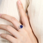 Load image into Gallery viewer, Sapphire and diamond ring on a person’s finger.
