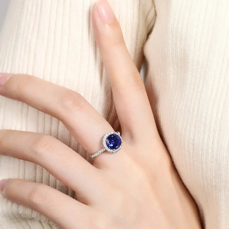 Sapphire and diamond ring on a person’s finger.