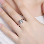 Load image into Gallery viewer, Diamond solitaire engagement ring on a finger.
