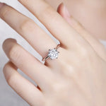 Load image into Gallery viewer, Diamond solitaire engagement ring on a finger.
