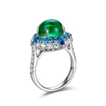 Load image into Gallery viewer, Ornate silver ring featuring a prominent green gemstone surrounded by blue and clear stones.
