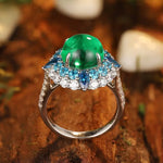 Load image into Gallery viewer, Ornate silver ring featuring a prominent green gemstone surrounded by blue and clear stones.
