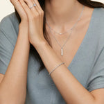 Load image into Gallery viewer, Delicate silver jewelry set including necklaces, bracelet, and ring worn by a person in a gray top.
