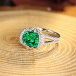 Load image into Gallery viewer, Elegant silver ring featuring a cushion-cut emerald surrounded by diamonds.
