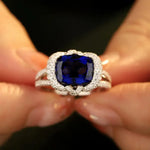 Load image into Gallery viewer, Sapphire and diamond ring held between fingertips.
