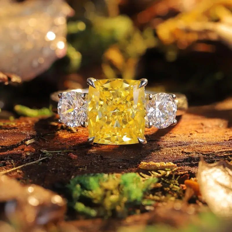 Dazzling yellow diamond ring flanked by two clear diamonds.