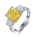 Load image into Gallery viewer, Silver ring featuring a prominent yellow cushion-cut diamond flanked by two smaller white diamonds.
