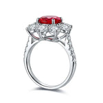 Load image into Gallery viewer, Ornate silver ring featuring a central red gemstone surrounded by clear diamonds.
