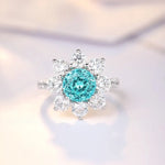 Load image into Gallery viewer, Snowflake-shaped ring with a central turquoise gemstone surrounded by clear diamonds.
