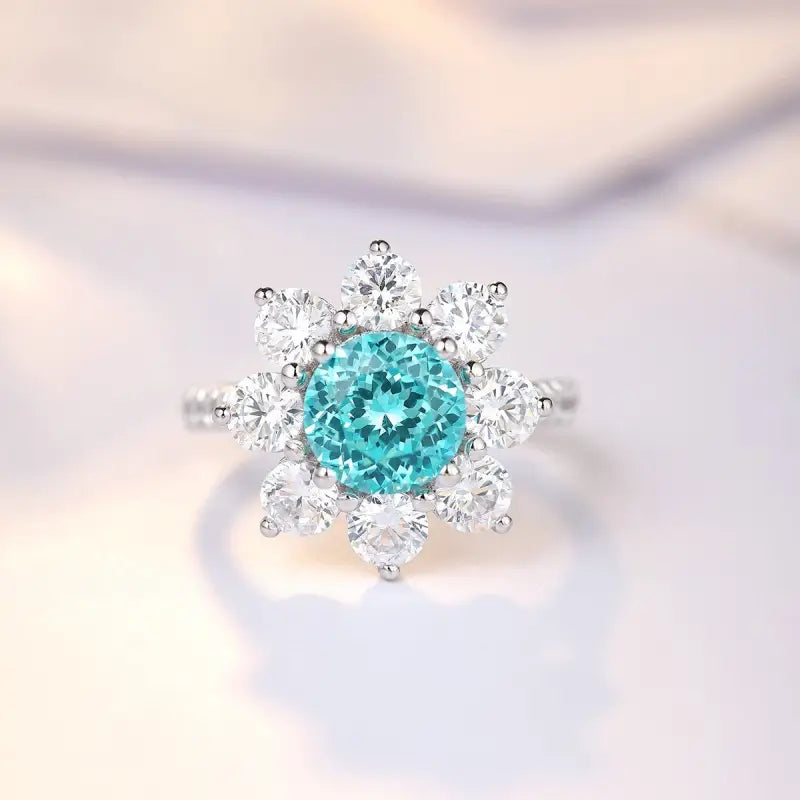 Snowflake-shaped ring with a central turquoise gemstone surrounded by clear diamonds.