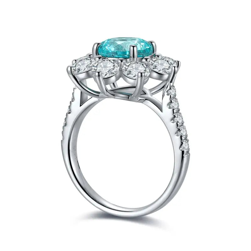 Elegant silver ring featuring a central teal gemstone surrounded by clear diamonds.