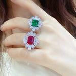 Load image into Gallery viewer, Ornate ring featuring two gemstones, an emerald and a ruby, surrounded by diamonds.
