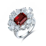 Load image into Gallery viewer, Ornate silver ring featuring a central rectangular ruby surrounded by diamond accents.
