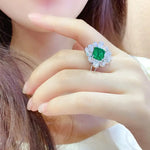 Load image into Gallery viewer, Ornate ring featuring a square emerald surrounded by diamonds.
