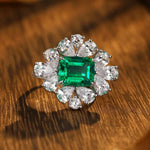 Load image into Gallery viewer, Ornate ring featuring a square emerald gemstone surrounded by diamond accents.
