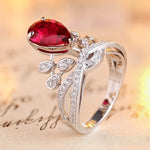 Load image into Gallery viewer, Elegant silver ring featuring a teardrop-shaped ruby and diamond accents in a floral design.
