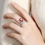 Load image into Gallery viewer, Ornate ring featuring a red gemstone and diamond-like accents in a floral design.
