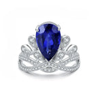 Load image into Gallery viewer, Ornate silver ring featuring a pear-shaped blue gemstone surrounded by diamond accents.
