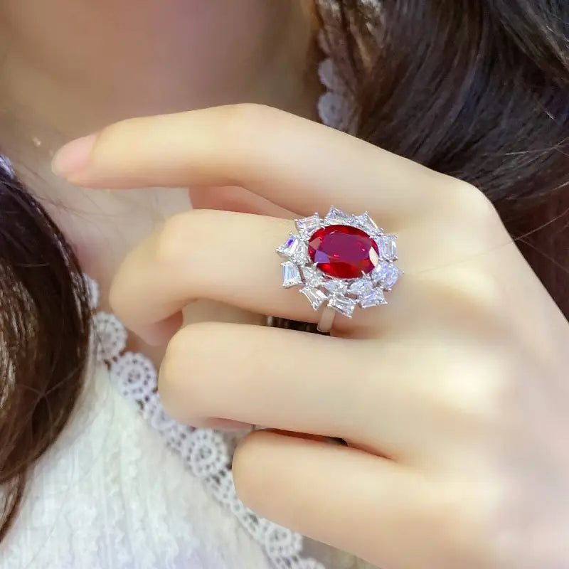 Ornate ring featuring a vibrant red gemstone surrounded by smaller clear stones.