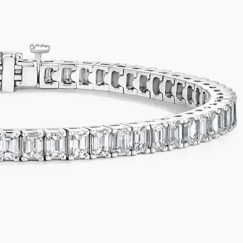 Diamond tennis bracelet featuring emerald-cut stones set in a line.