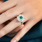 Load image into Gallery viewer, Emerald and diamond ring worn on a finger.
