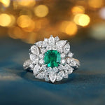 Load image into Gallery viewer, Ornate diamond ring featuring a central emerald-cut green gemstone surrounded by pear-shaped diamonds.
