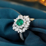 Load image into Gallery viewer, Ornate diamond ring featuring a central emerald-cut green gemstone surrounded by white diamonds.
