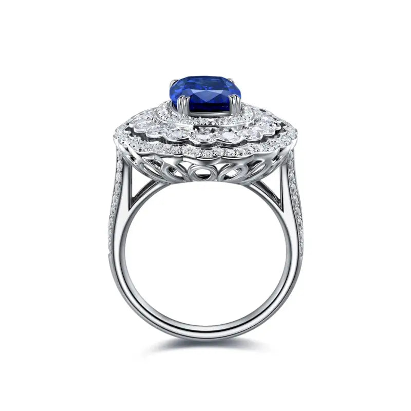 Ornate silver ring featuring a central blue gemstone surrounded by diamonds.