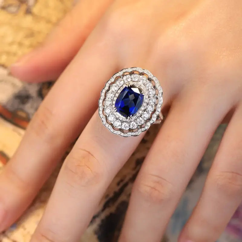 Ornate ring featuring a deep blue oval gemstone surrounded by diamonds.