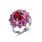 Load image into Gallery viewer, Ornate ring featuring a central red gemstone surrounded by pink gemstones in a floral-inspired setting.
