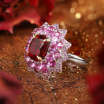 Load image into Gallery viewer, Ornate ring featuring a central red gemstone surrounded by pink and clear stones in a floral-like design.
