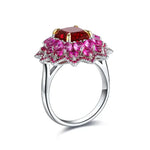 Load image into Gallery viewer, Ornate silver ring featuring a large red gemstone surrounded by pink gemstones in a floral design.
