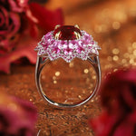 Load image into Gallery viewer, Ornate silver ring featuring a central red gemstone surrounded by pink gemstones in a floral-like arrangement.
