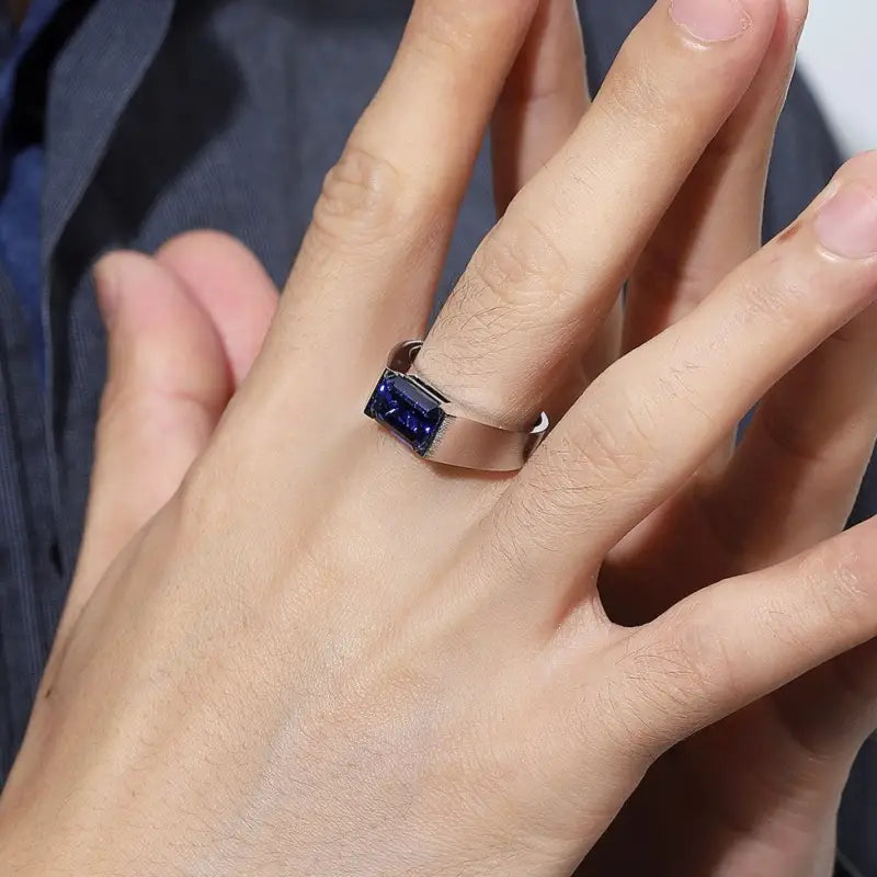 Sapphire ring on a person’s hand.