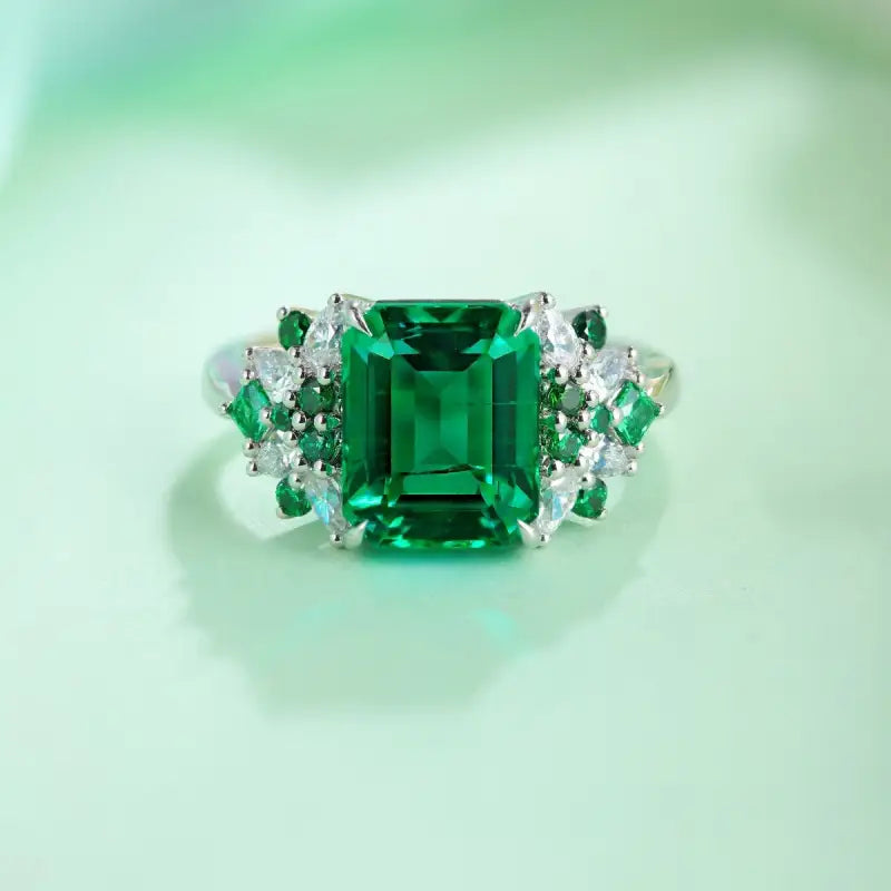 Emerald-cut green gemstone ring with diamond accents.