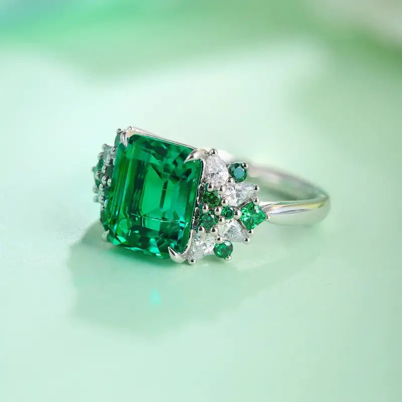 Emerald-cut green gemstone ring with diamond accents.