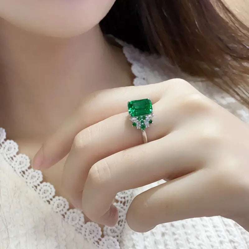 Emerald-cut green gemstone ring with small diamond accents.