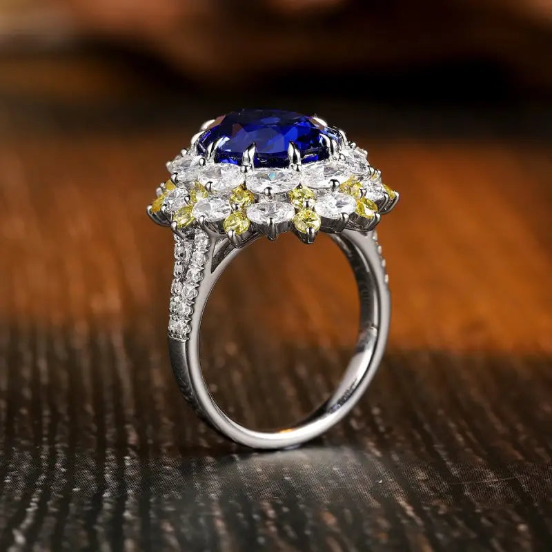 Ornate silver ring featuring a prominent blue gemstone surrounded by smaller white and yellow stones.