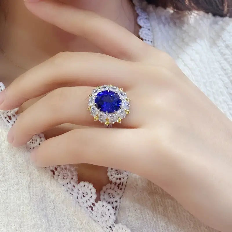 Ornate ring featuring a vibrant blue gemstone surrounded by smaller clear stones.