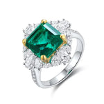 Load image into Gallery viewer, Emerald and diamond ring with a square-cut green gemstone centerpiece surrounded by smaller white diamonds.
