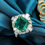 Load image into Gallery viewer, Emerald-cut green gemstone ring surrounded by smaller white diamonds.
