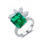 Load image into Gallery viewer, Emerald and diamond ring with a floral-inspired design set in white metal.
