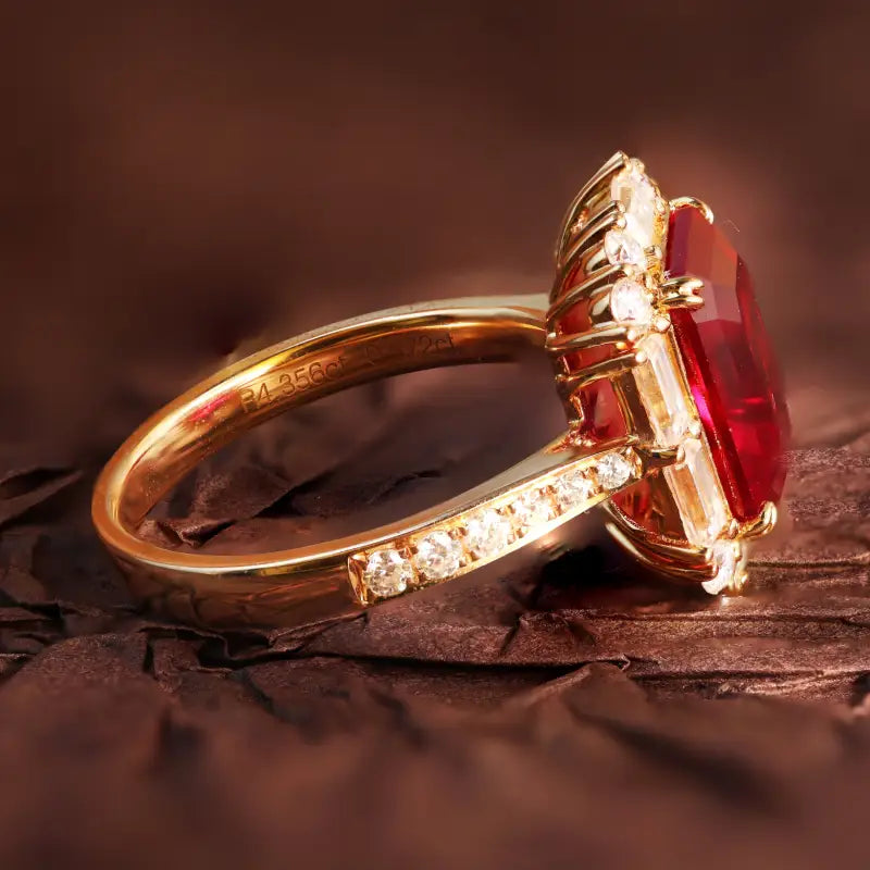 Gold ring with a prominent rectangular red gemstone and small diamonds along the band.