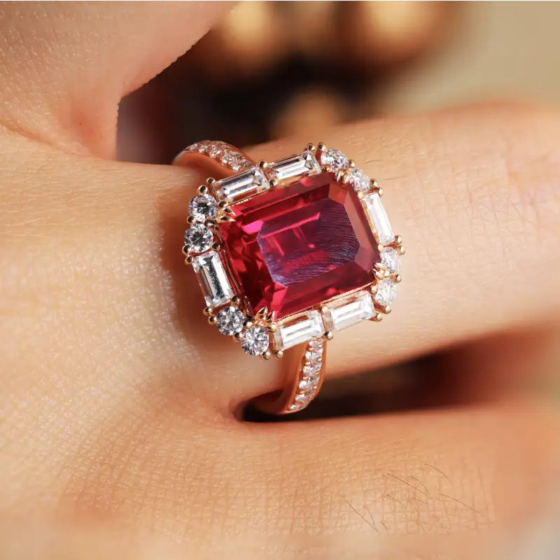 Ornate ring featuring a square-cut red gemstone surrounded by diamonds.