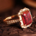 Load image into Gallery viewer, Ornate gold ring featuring a prominent square-cut ruby surrounded by diamonds.
