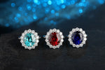 Load image into Gallery viewer, Three ornate gemstone rings featuring blue, red, and purple center stones surrounded by diamonds.
