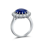 Load image into Gallery viewer, Elegant silver ring featuring a deep blue oval gemstone surrounded by smaller white stones.
