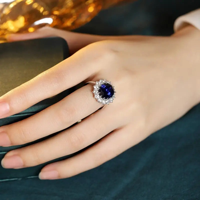 Ornate ring featuring a deep blue gemstone surrounded by smaller clear stones.