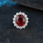 Load image into Gallery viewer, Ornate ring featuring a pear-shaped deep red gemstone surrounded by smaller white diamonds.
