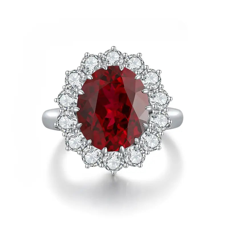 Ornate ring featuring a deep red oval gemstone surrounded by smaller clear stones.